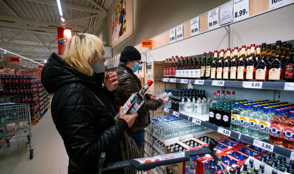 Посетители у полки с алкогольной продукцией в магазине
