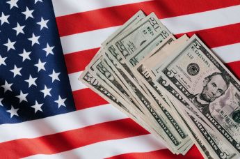 Купюры доллара и флаг США