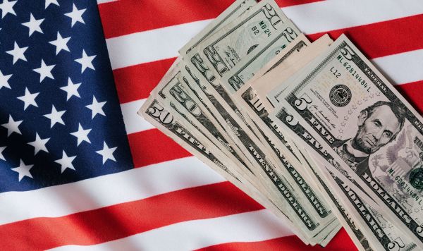 Купюры доллара и флаг США Купюры доллара и флаг США