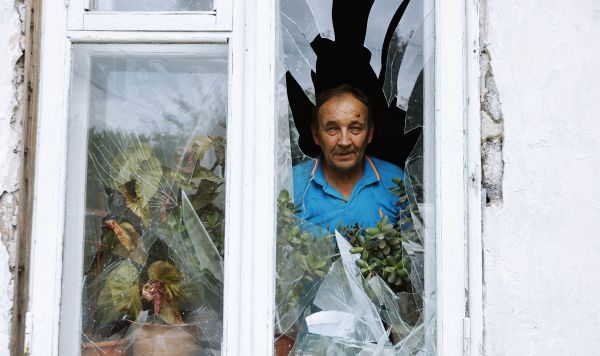 Мужчина смотрит из окна своего дома в Куйбышевском районе Донецка, получившего повреждения в результате обстрела со стороны ВСУ Мужчина смотрит из окна своего дома в Куйбышевском районе Донецка, получившего повреждения в результате обстрела со стороны ВСУ