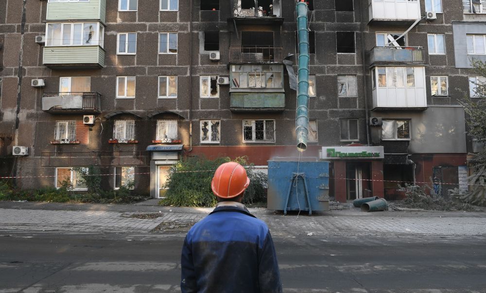 Рабочие во время работ по восстановлению жилого дома на одной из улиц в Мариуполе