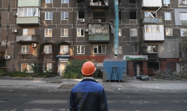 Рабочие во время работ по восстановлению жилого дома на одной из улиц в Мариуполе