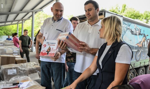 Заместитель председателя правительства ДНР Евгений Солнцев, председатель правительства ДНР Виталий Хоценко и министр образования и науки ДНР Ольга Колударова (слева направо) во время приема груза с новыми учебниками в Донецке.