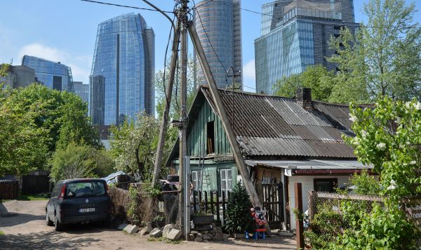 Деревянный частный дом на фоне небоскребов в деловом районе Вильнюса Деревянный частный дом на фоне небоскребов в деловом районе Вильнюса