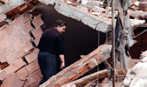 Женщина смотрит на руины своего дома в Сурдулице, 28 апреля 1999 года Женщина смотрит на руины своего дома в Сурдулице, 28 апреля 1999 года
