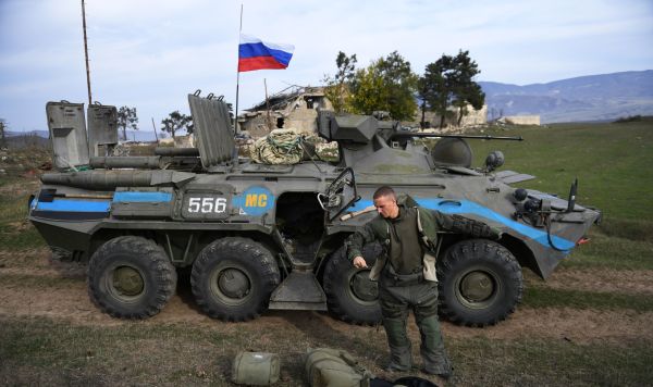 Российский военнослужащий подразделения гуманитарного разминирования у БТР-80 в Нагорном Карабахе