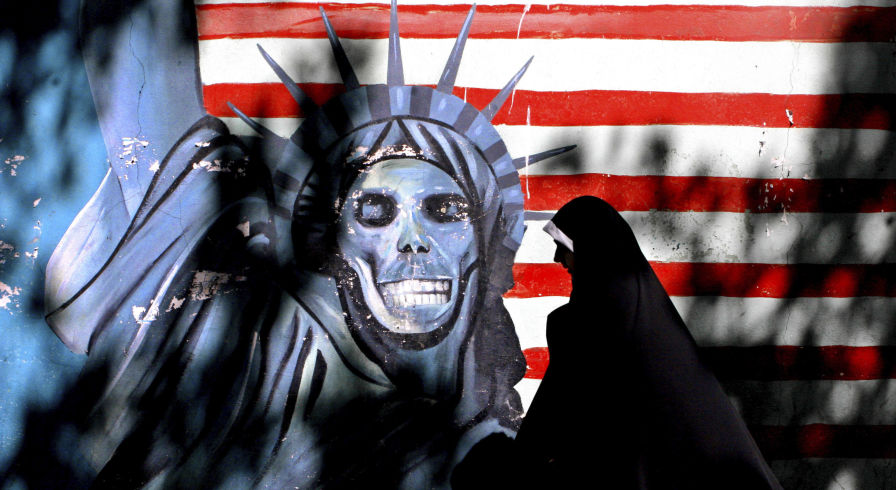 Женщина проходит мимо граффити Статуя Свободы, нарисованная на стене бывшего здания США. Посольство в Тегеране, Иран. Архивное фото