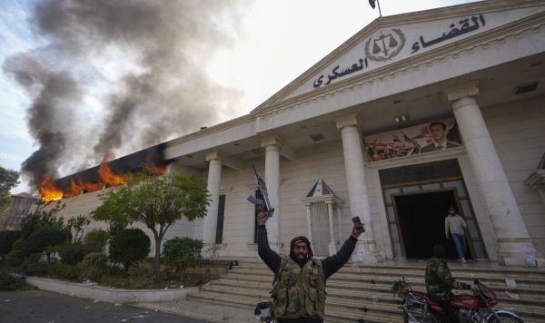 Сирийские повстанцы Сирийские повстанцы празднуют победу, в то время как горит здание военного суда в Дамаске