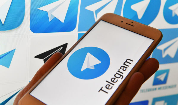Логотип мессенджера Telegram на экранах смартфона и компьютера. Логотип мессенджера Telegram на экранах смартфона и компьютера.