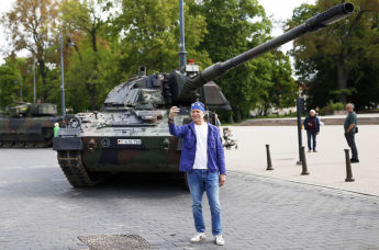 Мужчина делает селфи у немецкого танка перед официальным открытием немецкой бригады для восточного фланга НАТО в центре Вильнюса, Литва