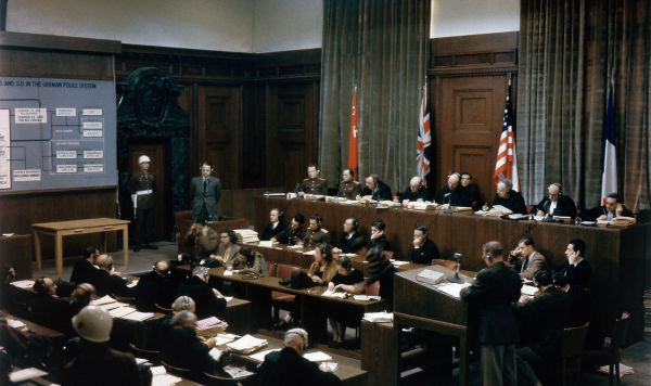 Судебный процесс над руководителем СС Эрнстом Кальтенбруннером (1903–1946, стоит слева) в зале Дворца правосудия во время Международного военного трибунала (МВТ) в Нюрнберге, Германия, 19–20 декабря 1945 года. Судебный процесс над руководителем СС Эрнстом Кальтенбруннером (1903–1946, стоит слева) в зале Дворца правосудия во время Международного военного трибунала (МВТ) в Нюрнберге, Германия, 19–20 декабря 1945 года.