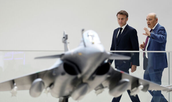 Президент Франции Эммануэль Макрон (слева) рассматривает макет истребителя Rafale.