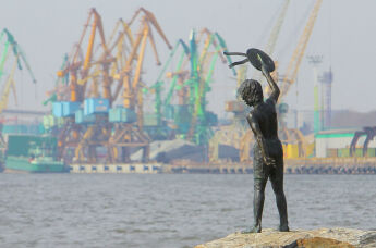 Памятник мальчику с бескозыркой и собакой, который провожает корабли в морском грузовом порту Клайпеды