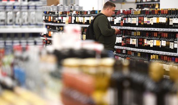 Покупатель в отделе алкогольной продукции гипермаркета