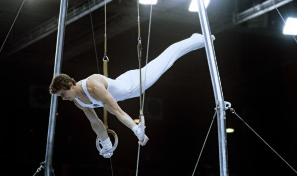 Александр Дитятин, абсолютный Олимпийский чемпион 1980 года по спортивной гимнастике, выполняет упражнение на кольцах. XXII летние Олимпийские игры. Александр Дитятин, абсолютный Олимпийский чемпион 1980 года по спортивной гимнастике, выполняет упражнение на кольцах. XXII летние Олимпийские игры.