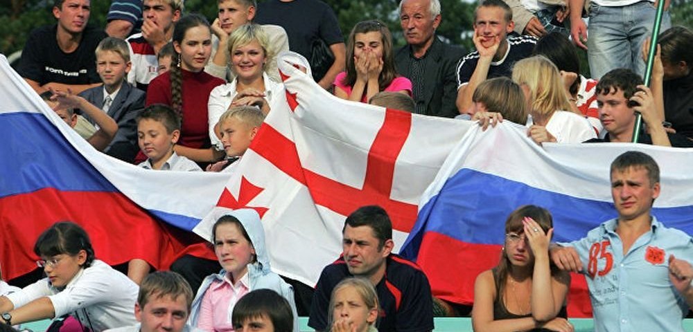 Люди с флагами России и Грузии.
